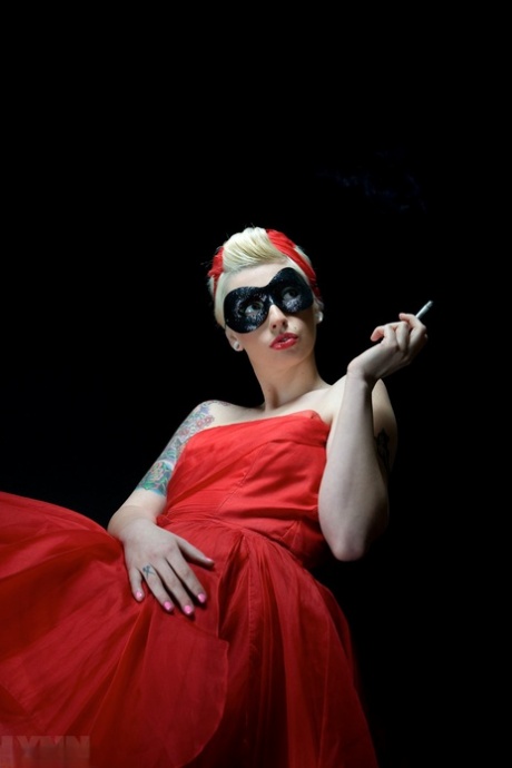 Tattooed blonde Lynn Pops smokes while letting her boobs free of a red dress 94553304