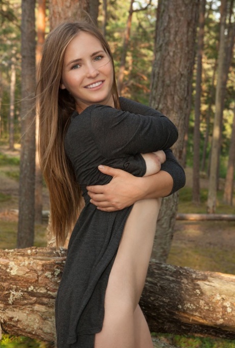 Busty teen Narina A poses totally naked on a fallen tree in a forest 49752906