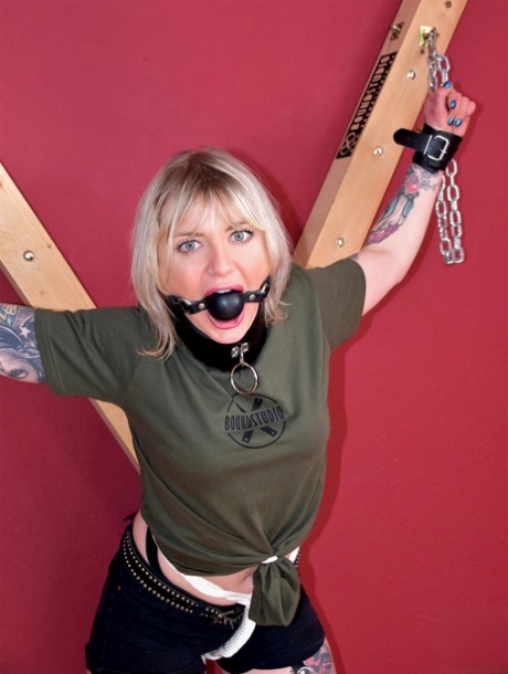 Blonde chick Roxxxi Manson is ball gagged while chained to a St Andrews cross 98452505