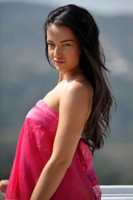Gorgeous brunette Kayleigh gets naked on a balcony in garters and nylons 21419340