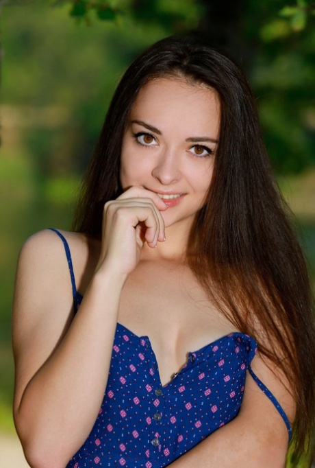 Beautiful brunette teen Chanel C gets naked atop her dress in a forest 69456261